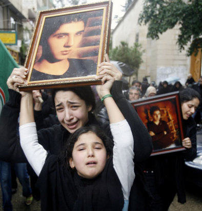 قريبات للشهيد أحمد علي العجوز يحملن صورته