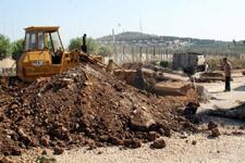 جرافة تزيل رصيفاً محاذياً للشريط الحدودي