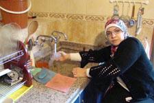 ميرفت تغسل كوباً على المجلى داخل المنزل