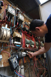 عامل يفحص عدادات الكهرباء