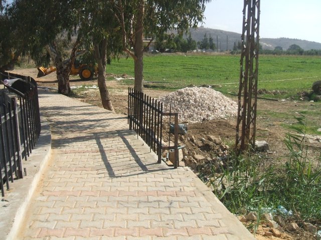 جانب من المشروع يظهر الرصيف المحيط بالبركة والسياج الحديدي