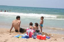 أفراد العائلة يستمتعون بمياه البحر وصوت تكسّر أمواجه