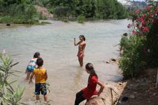 يستمتعون ببرودة مياه نهر الأولي