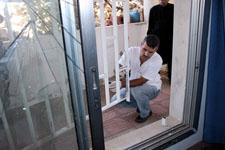 رجل من الأدلة الجنائية يرفع البصمات في مقام الداعي عمار