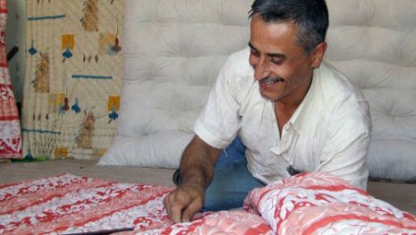  يضحك ساخراً على زوال مهنة التنجيد التراثية