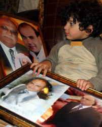 يحمل جواد صورة والده، وعمه كأنه يعي ما يدور حوله