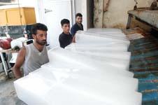 عمال يوضبون ألواح الثلج بعد صناعتها