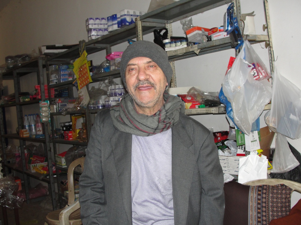 أبو قاسم محمد علي أحمد في محلّه التجاري الذي افتتحه بعد عودة الأهالي إلى الخيام مطلع الثمانينات