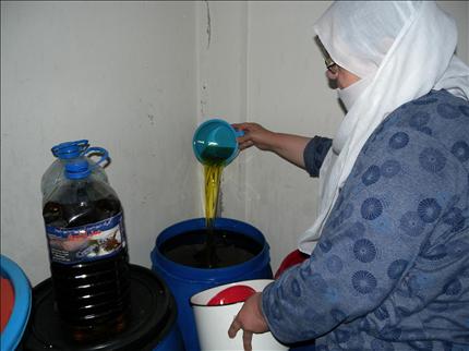 مواطنة تتفحص خوابي الزيت الممتلئة في حاصبيا