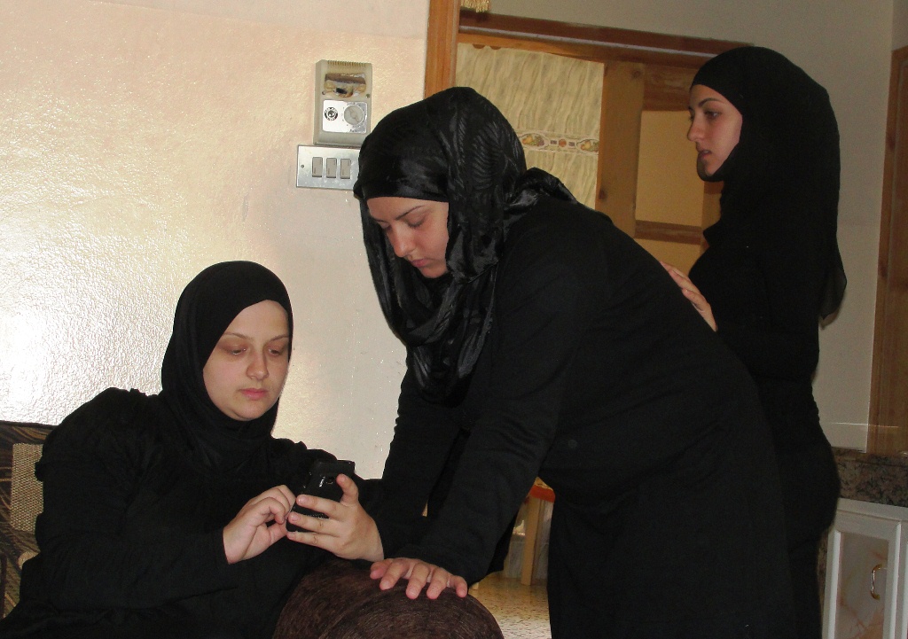 شقيقات عُلا يتصفحن صور شقيقتهن الراحلة