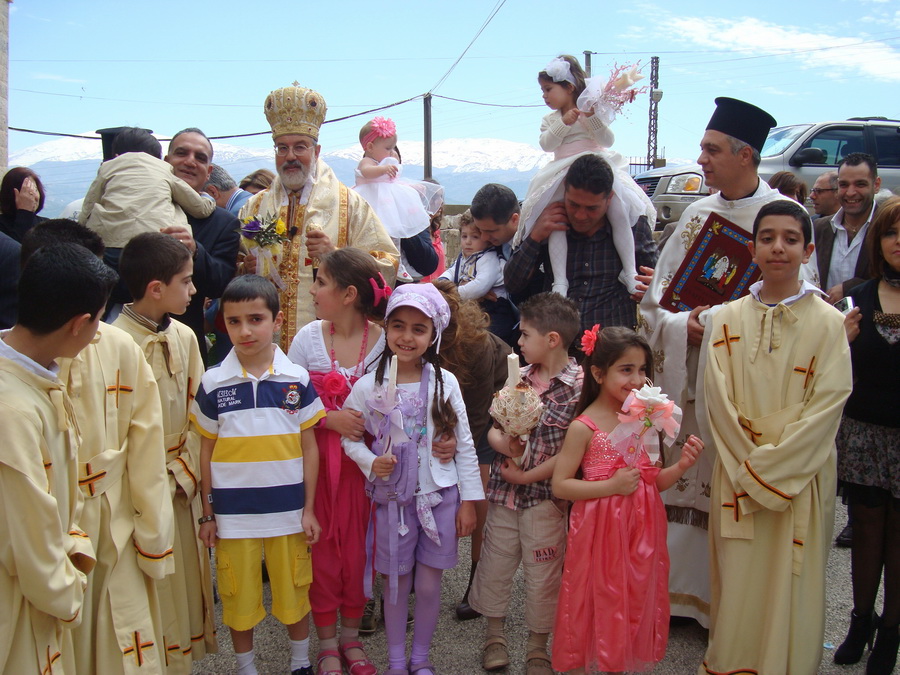المطران حداد يحيط به الاطفال خلال زياح احد الشعانين في كنيسة مار بطرس في مرجعيون