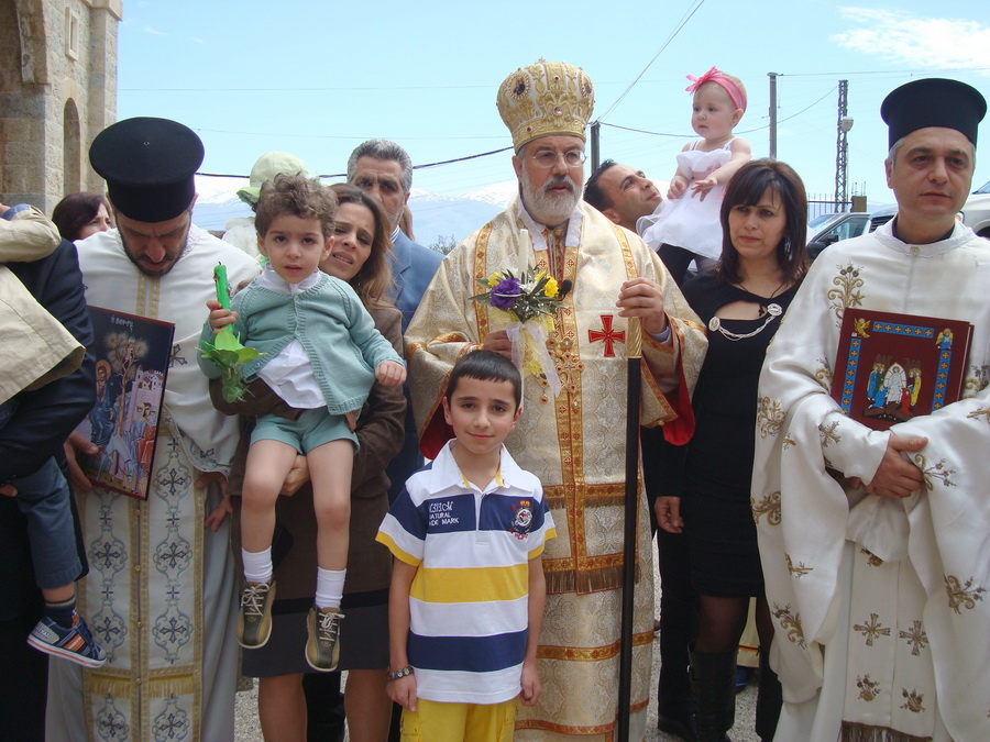 المطران حداد يحيط به الاطفال والكهنة في زياح الشعانين