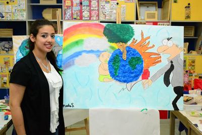 مدى صادق إلى جانب لوحتها عن البيئة