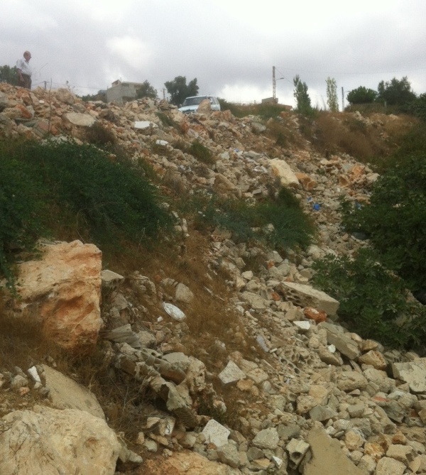  كرم تين وزيتون يتحوّل إلى مكبّ بعد رمي مئات الأطنان من الردم والأنقاض فيه