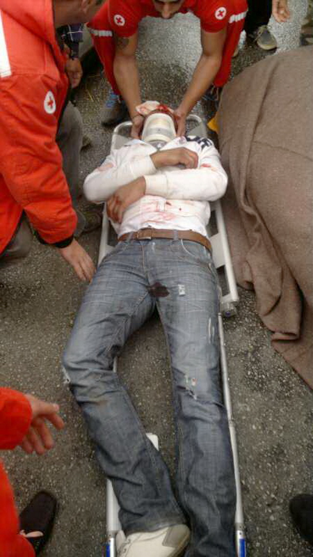 عناصر من الصليب الاحمر تعمل على نقل الجريح الى المستشفى