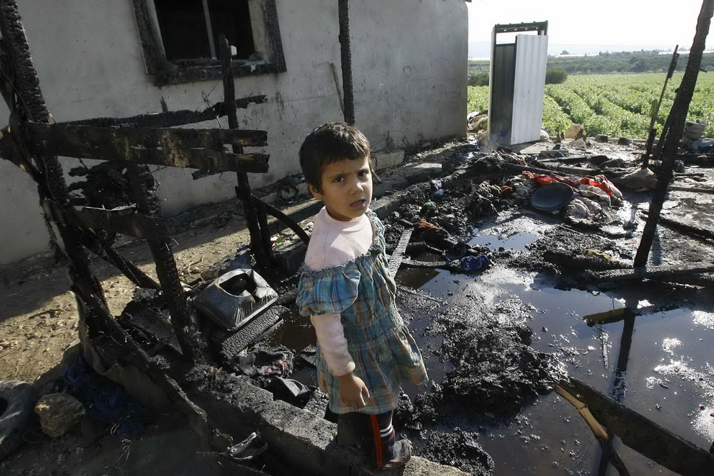 طفلة بين انقاض الخيمة المحترقة
