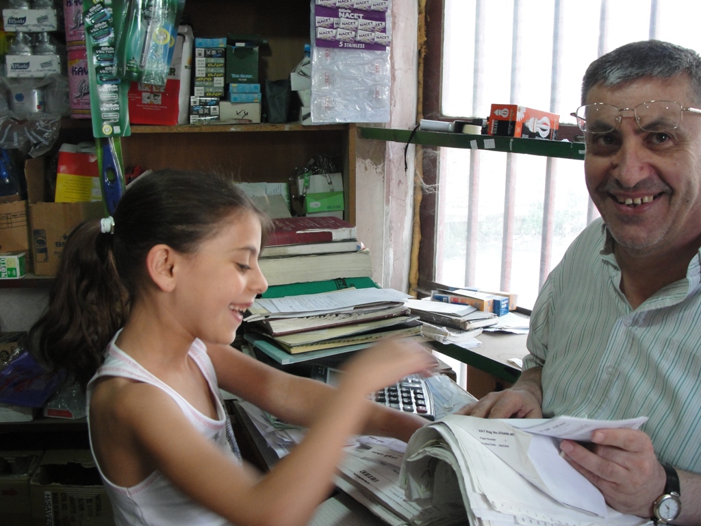 أحمد ابراهيم في متجره وابنته الصغرى فاطمة