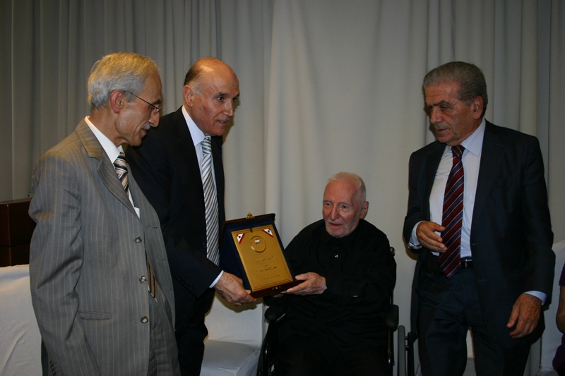 الدكتور كامل مهنا يقدم درعا تقديريا  للمطران حداد بإسم تجمع الهيئات الأهلية - أرشيف