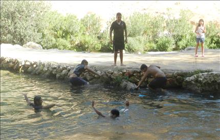 يلهون على ضفة الوزاني أمس (طارق أبو حمدان)