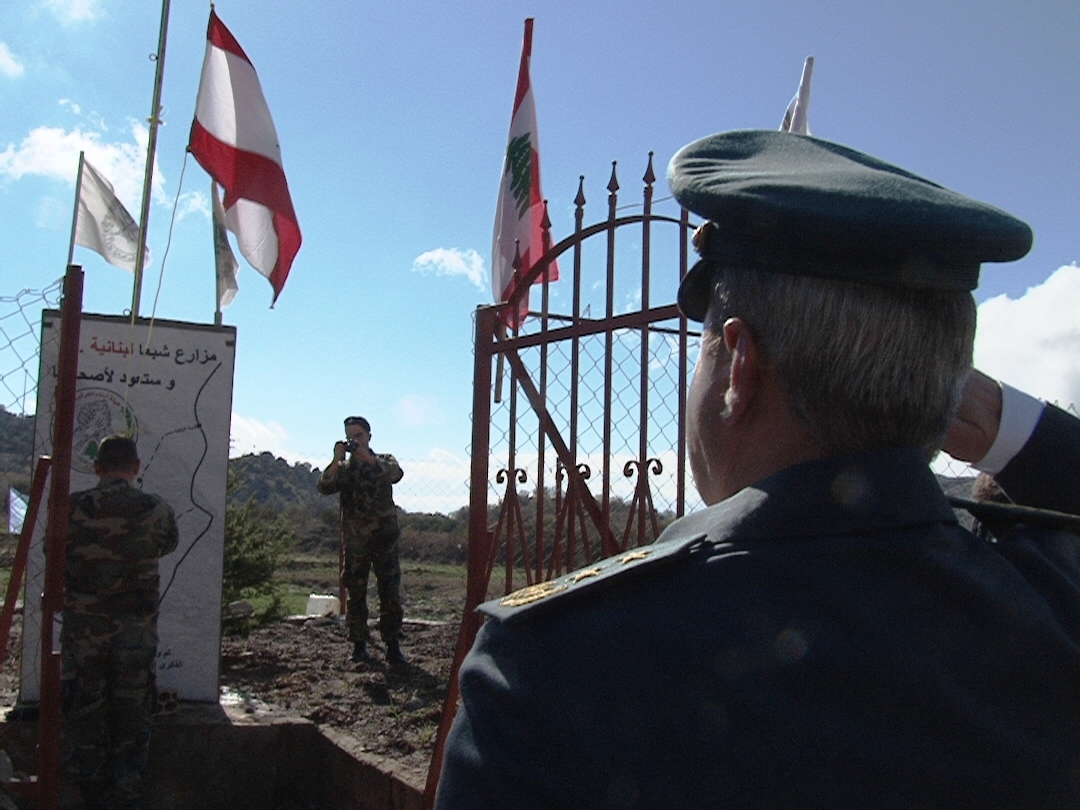 العقيد نصري عليق يؤدي التحية عند رفع العلم عند بوابة المزارع