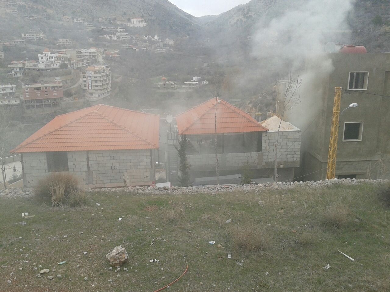 الدخان يتصاعد من احد المنازل الذي أضرم فيه النار المضطرب عقلياً 