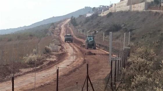 آلية جرار خلفها سلاسل لتنظيف الطريق الترابية وسط حراسة امنية لالية من نوع جيب عسكري واخرى مصفحة