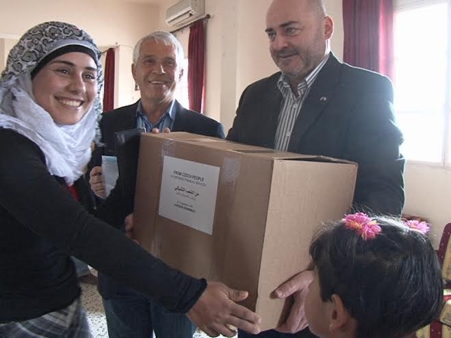 نازحة سورية تتسلم مساعدة انسانية من السفير التشيكي وبدا رئيس جمعية أغصان د. مرقص