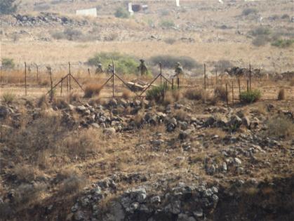 جنود العدو خلف السياج الحدودي في منطقة الوزاني