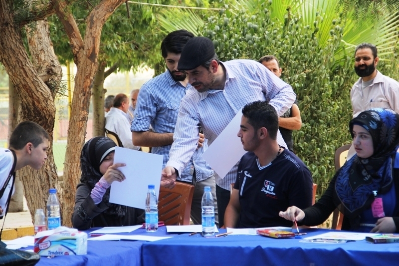 شرح من الفنان حسين بزي  عن تقنيات الرسم للمشاركين في الورشة