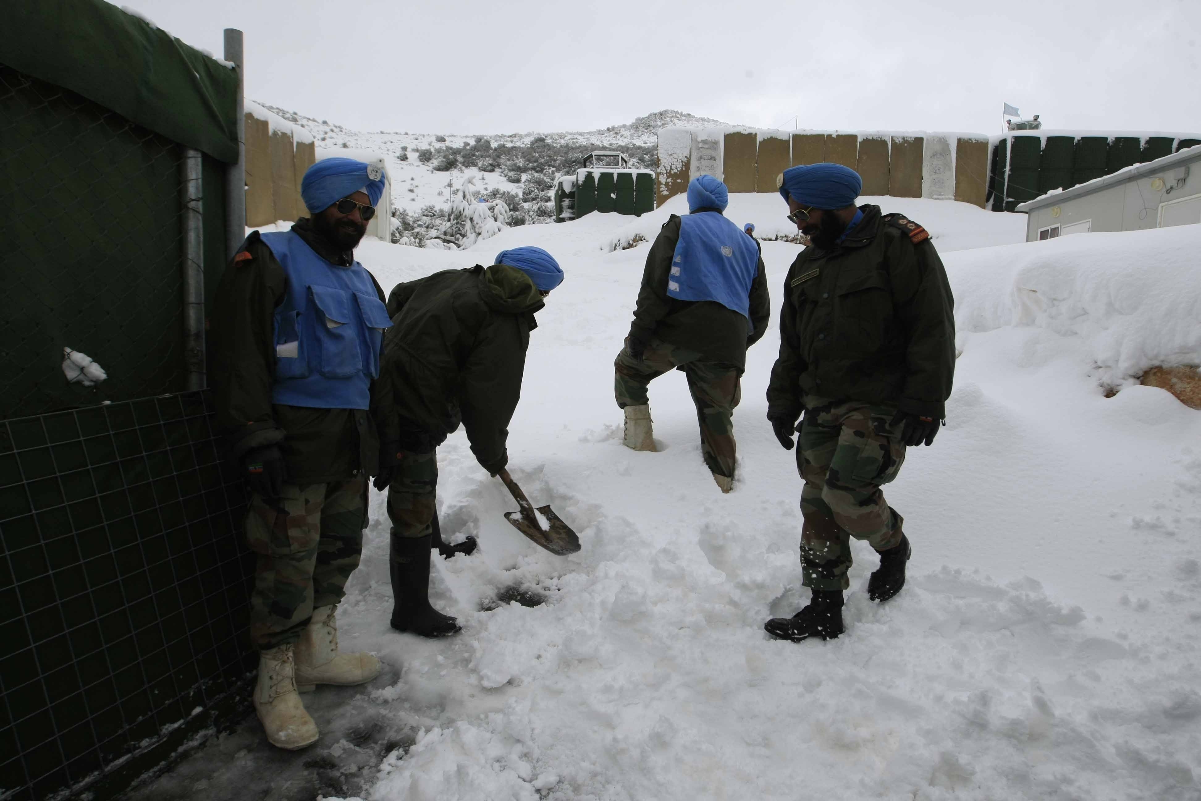 عناصر من الوحدة الهندية تزيل الثلج من أمام موقعهم في كفرشوبا