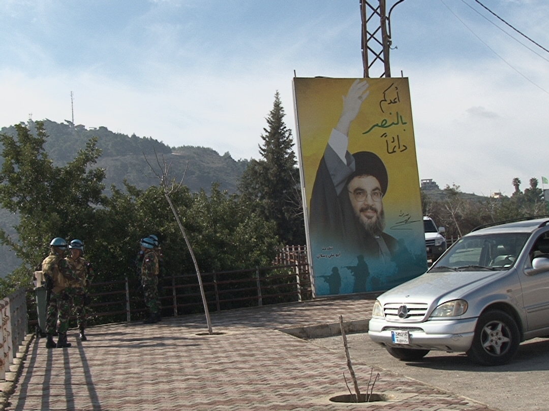 جنود دوليون يراقبون الخط الازرق وبدت صورة للسيد نصرالله