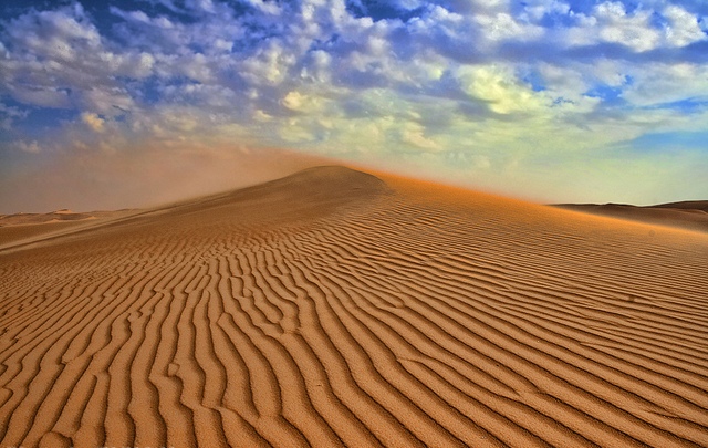 رغْم الرّمال تَطايرُ حوْلي ورغْم احْمِرار السّماءْ لقدْ كنتِ أنْتِ التّألُّقَ مِنْ بيْن ما أشْهَدُهْ