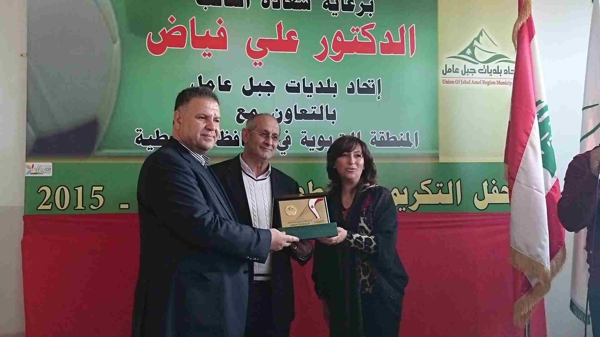 النائب علي فياض ورئيس الاتحاد علي الزين يقدمان درعاً لرئيسة المنطقة التربوية في محافظة النبطية نشأت الحبحاب