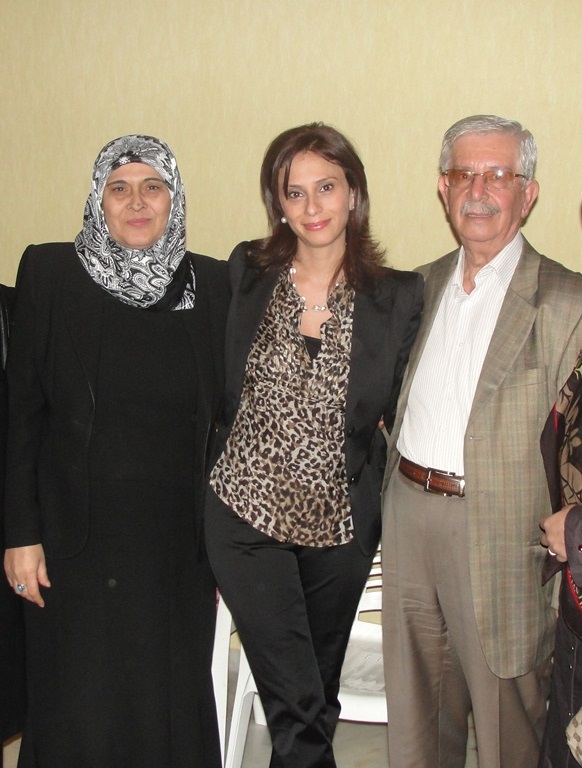 أخصائية التغذية فاطمة صادق تتوسط والديها (الحاج أبو علاء والحاجة أم علاء)