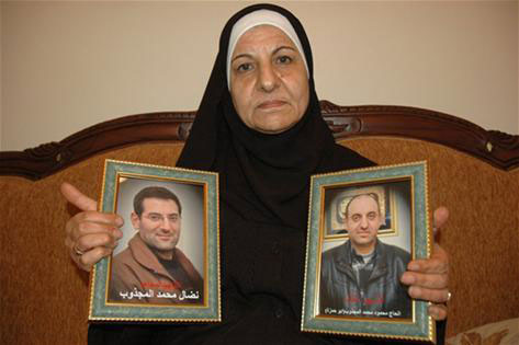 الحاجة خالدية الأتب تحمل صورة نجليها الشهيدين محمود ونضال المجذوب... متى يُنفّذ حكم الإعدام بالعملاء؟! 