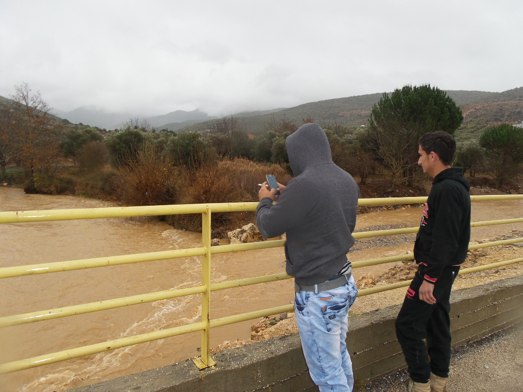 يلتقطان الصور للنهر باعلى ارتفاع منسوب المياه فيه