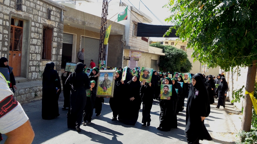 عوائل الشهداء يحملن صورهم