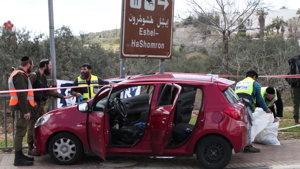 جنود الاحتلال يعاينون السيارة التي استخدمها منفذ العملية (الأناضول)