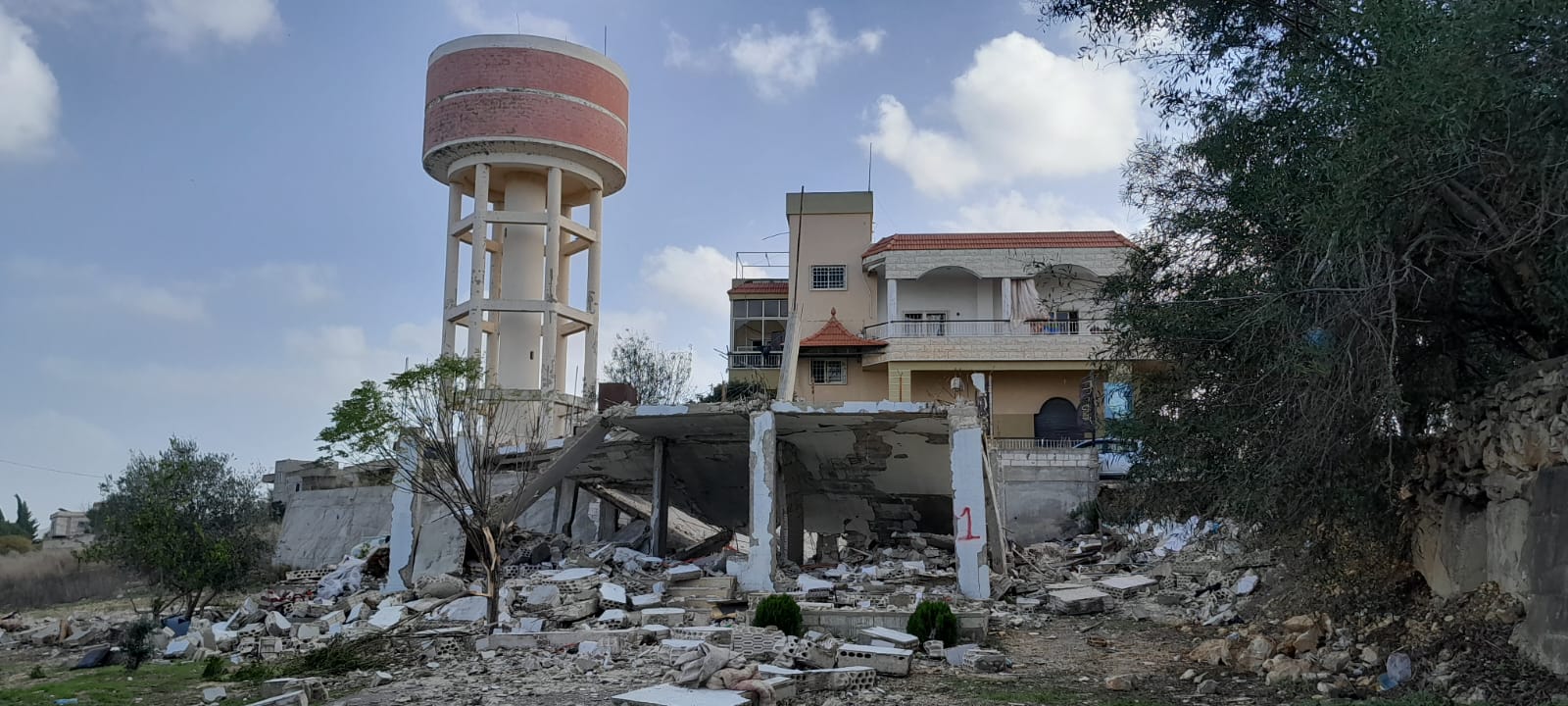 تشكّل حواويز المياه في الجنوب، جزءًا مهمًا من هوية البلدات.  الصورة تعود للدمار حول حاووز المياه في بلدة الجبين وقد التقطت في بداية الحرب العام 2023