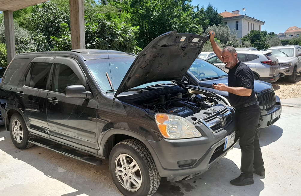 سعيد فقيه متفحصًا إحدى السيارات