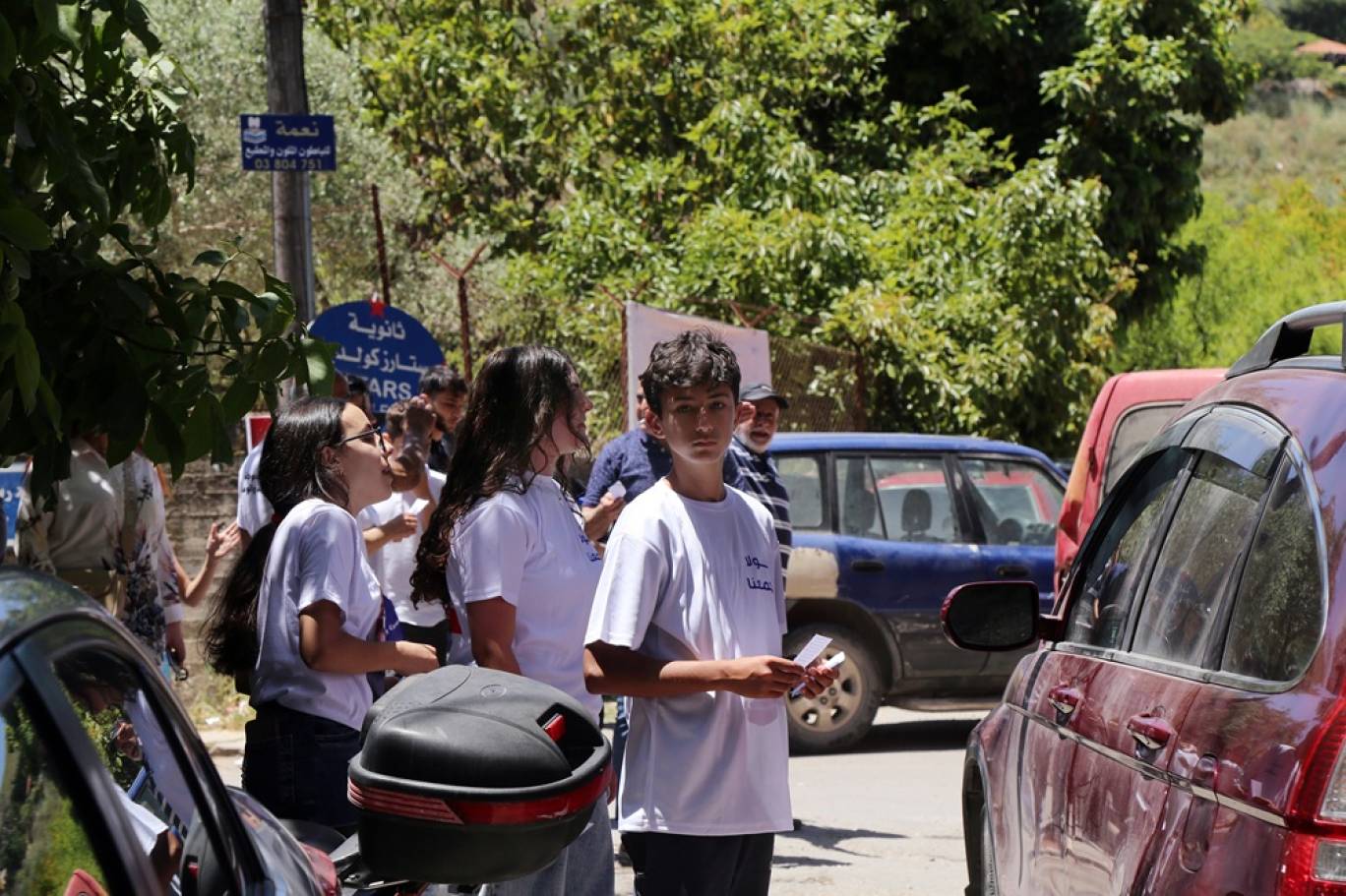 شبان وشابات من بلدة حولا الجنوبية يوزعون اللوائح الإنتخابية على الناخبين، السبت 24 مايو الحالي (اندبندنت عربية)