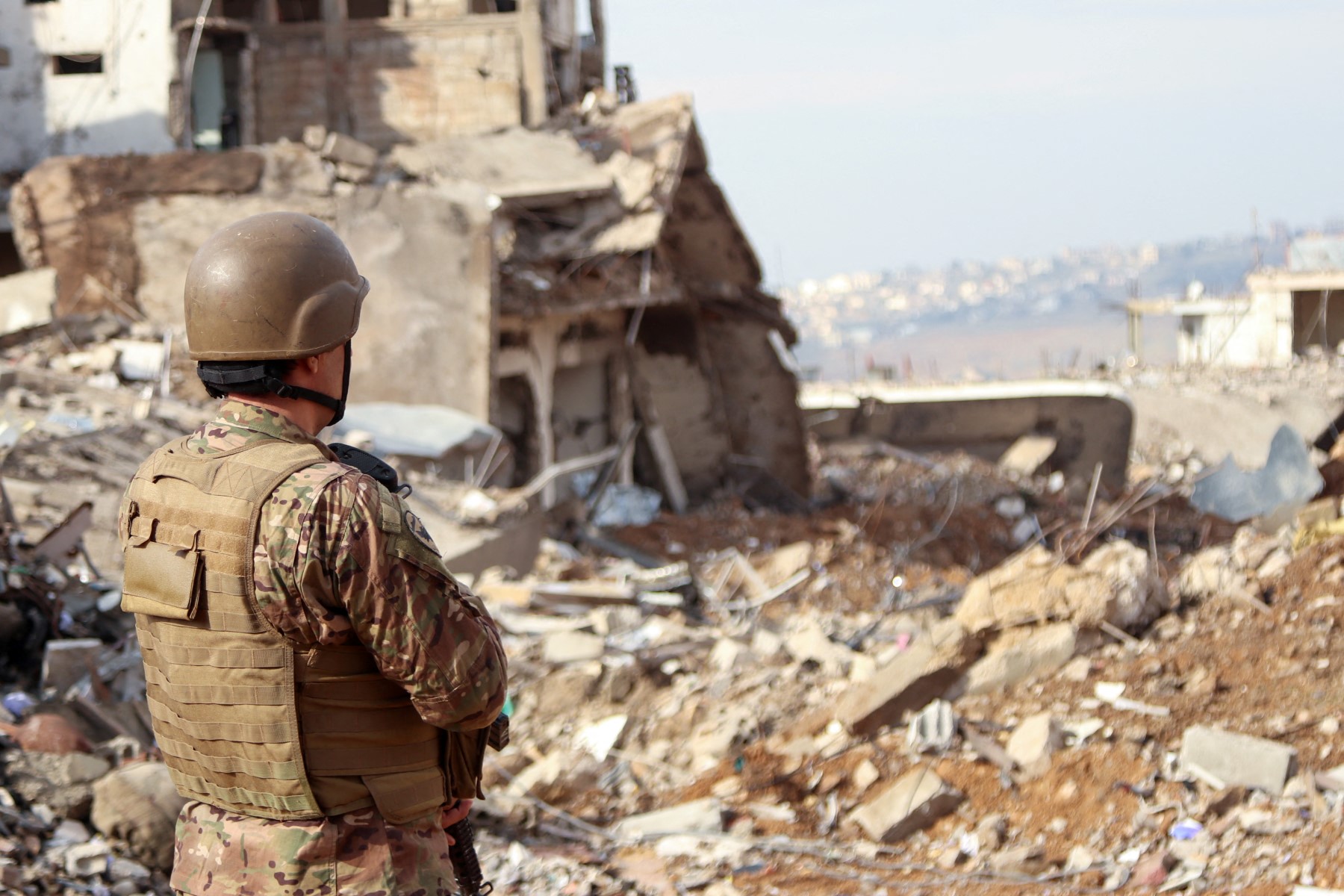 جندي لبناني يقف بين الدمار في بلدة الخيام جنوب لبنان (ا ف ب)